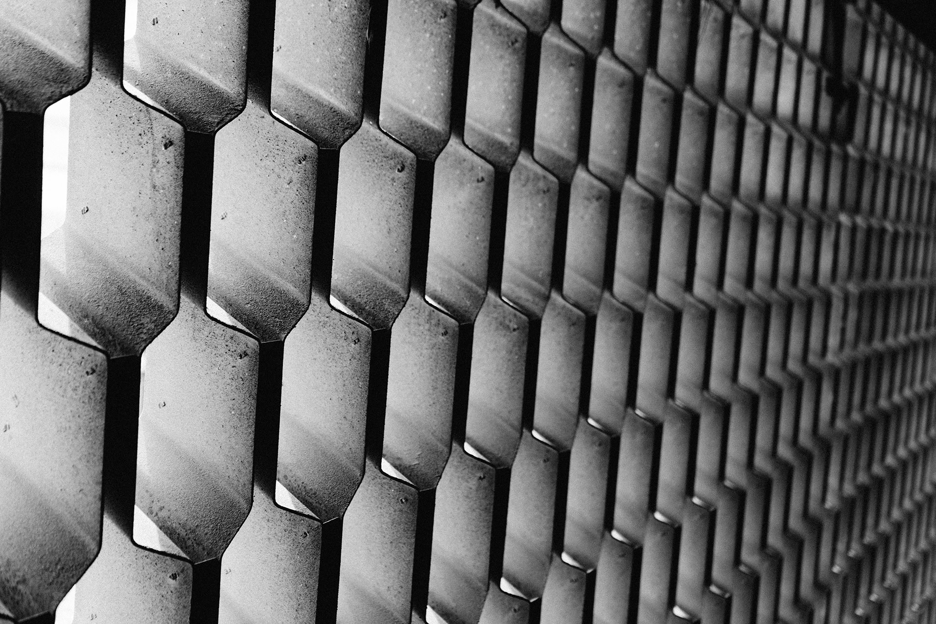 A macro shot of a metal fence in black and white