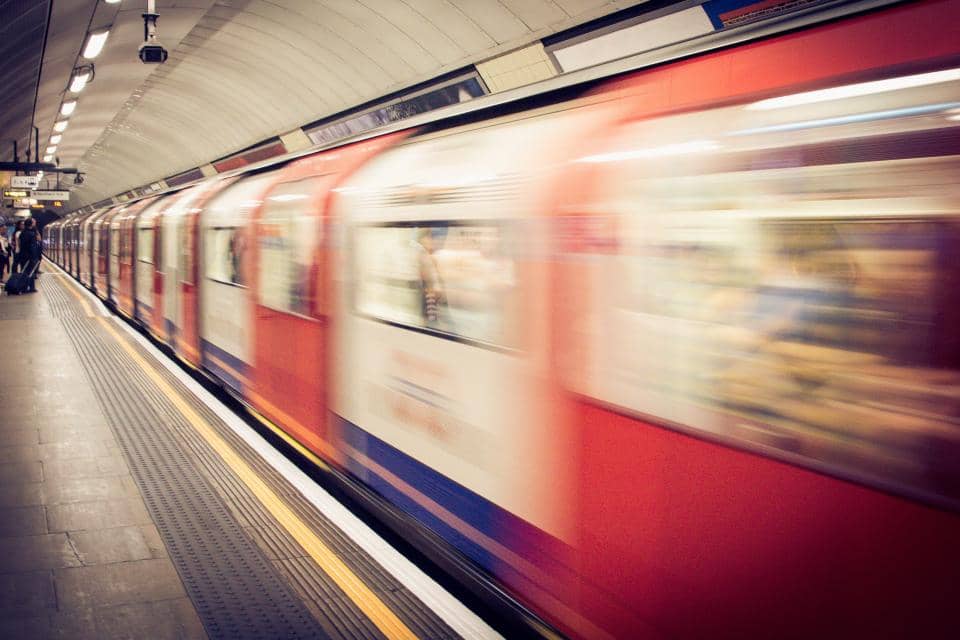 A subway train traveling at high speed through a station