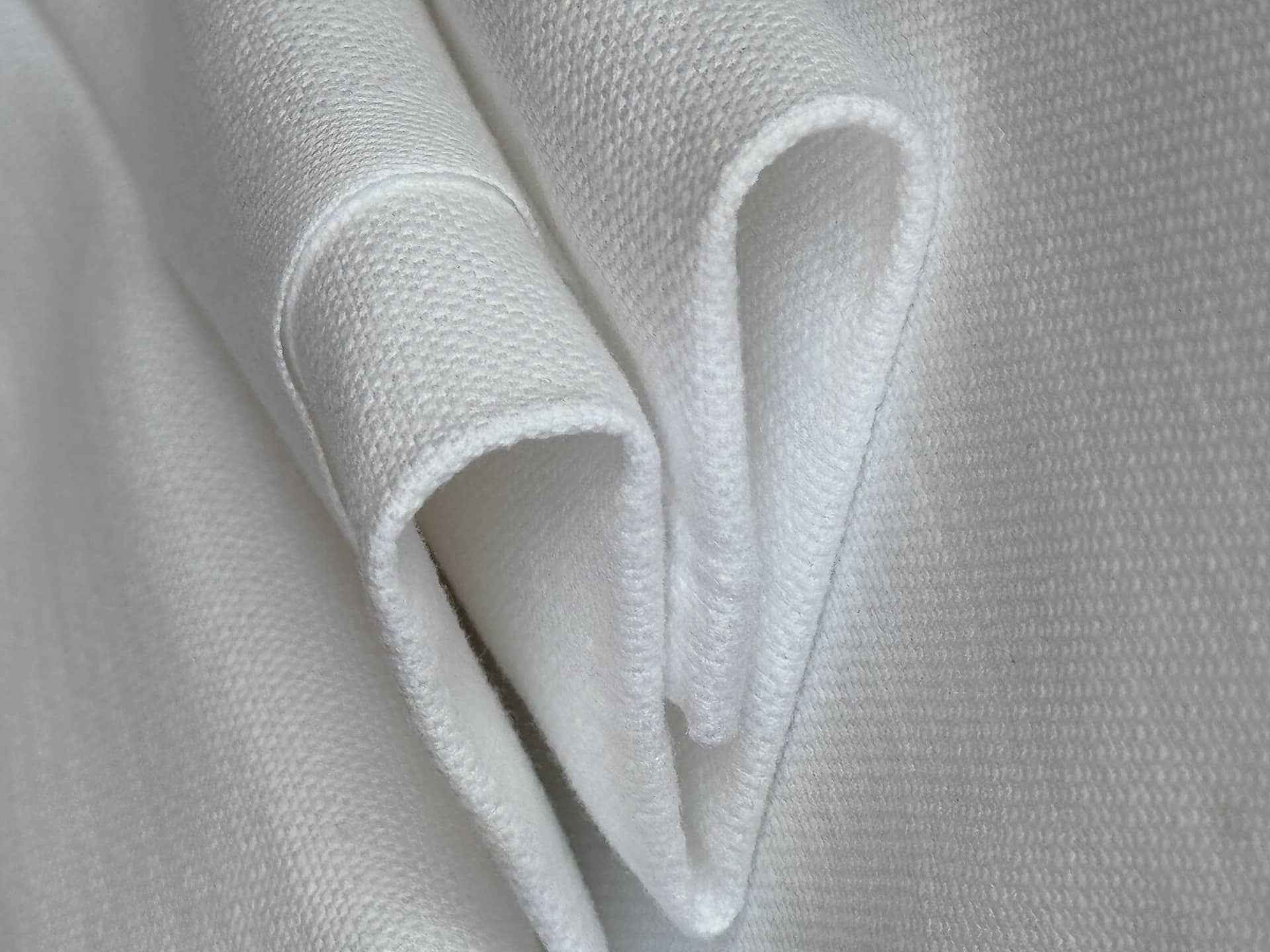 A white bed sheet folded into a heart shape